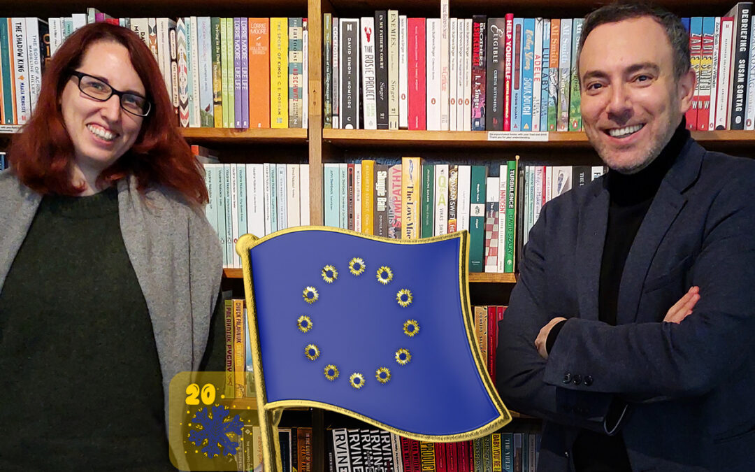 Sergey Lagodinsky und Sabine Grützmacher vor einem Bücherregal. Sie lächeln. Auf dem Bild eine goldene Anstecknadel in Form einer EU-Flagge. Die Sterne sind ersetzt durch goldene Sonnenblumen, das Logo von Bündnis90/DIE GRÜNEN.