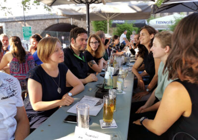 Das Team der Grünen aus EU-Parlament und Bundestag, Abgeordneten und Mitarbeitern beim Abendbrot am Deutzer Bahnhof, unter den Sonnenschirmen, verarbeitet die Eindrücke und Informationen des ersten Tages.